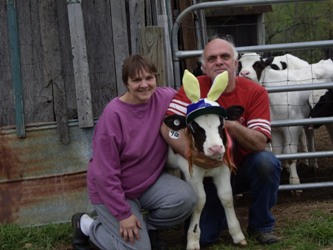 Bob and I kneeling with Fred the black and white calf between us.  Fred is wearing an easter bonnet with giant yellow bunny ears I made to cover the bald spot on top of his head where his hair fell out when he was sick with a fever.